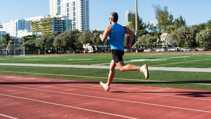 Coureur lancé sur une piste d'athlétisme Coureur lancé sur une piste d'athlétisme