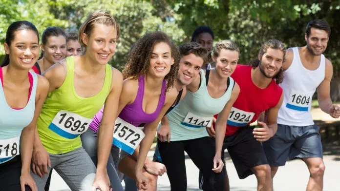 Coureurs souriants pendant une course dans un parc Coureurs souriants pendant une course dans un parc