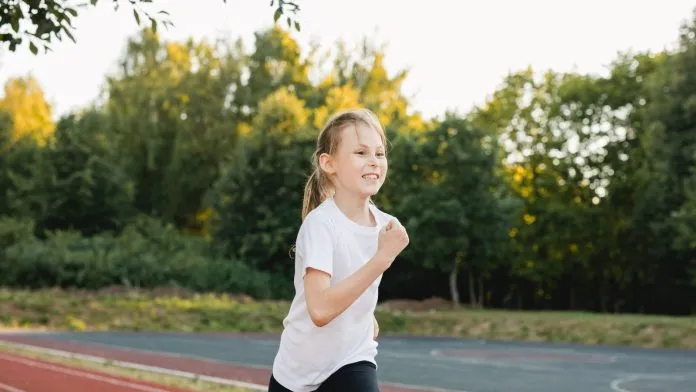 Une jeune athlète court sur une piste Une jeune athlète court sur une piste