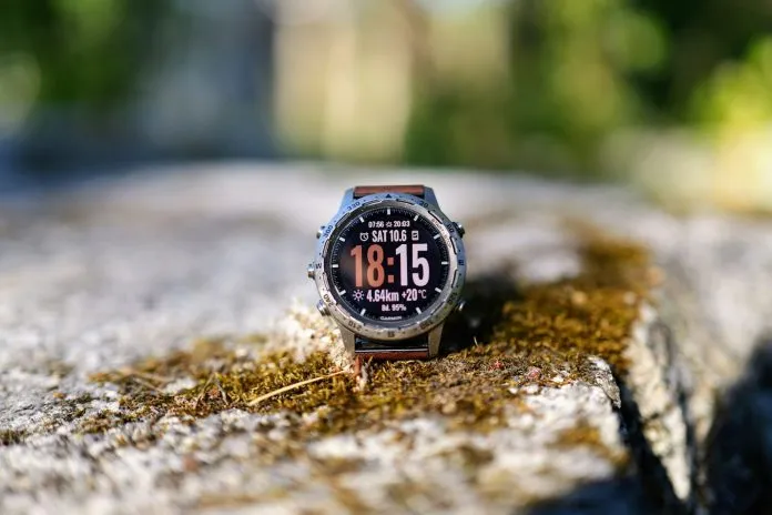 Montre GPS outdoor posée sur un rocher Montre GPS de sport posée sur un rocher couvert de mousse